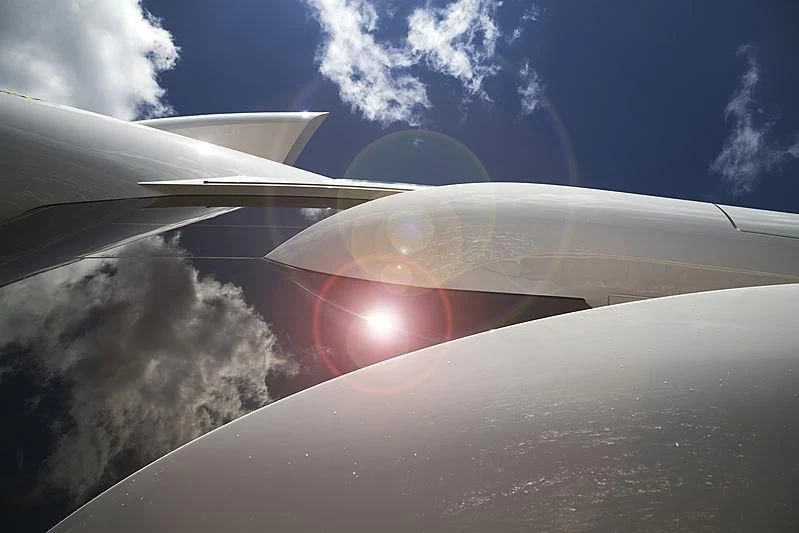 the wing of an airplane above the clouds aboard ARTEFACT Yacht for Sale