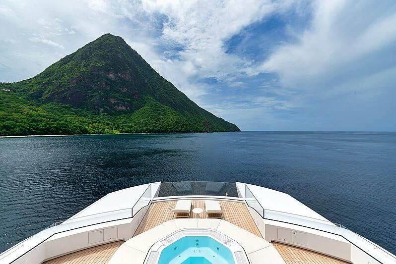 a boat on the water with Pitons in the background aboard ARTEFACT Yacht for Sale