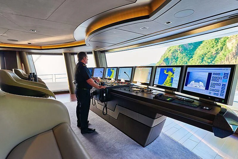 a person standing in front of a display of monitors aboard ARTEFACT Yacht for Sale