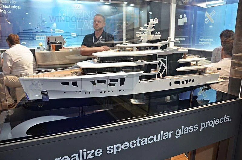 a person standing behind a display of a car aboard ARTEFACT Yacht for Sale