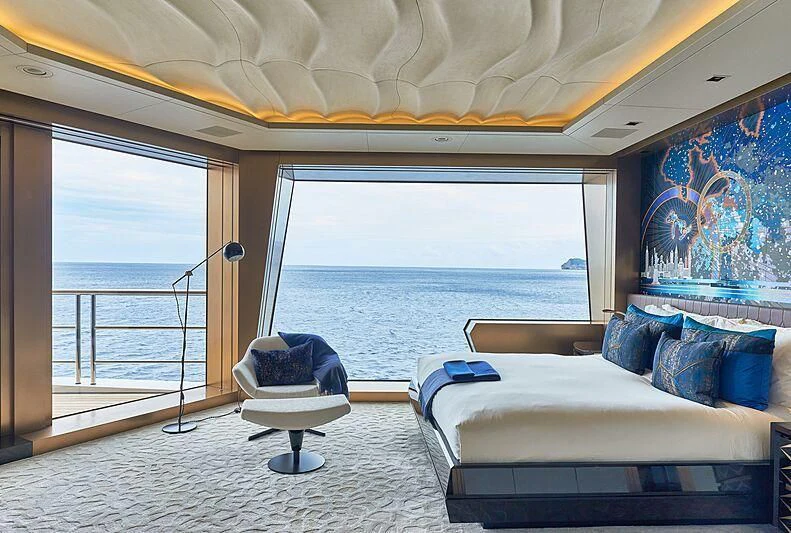 a room with a bed and a view of the ocean aboard ARTEFACT Yacht for Sale