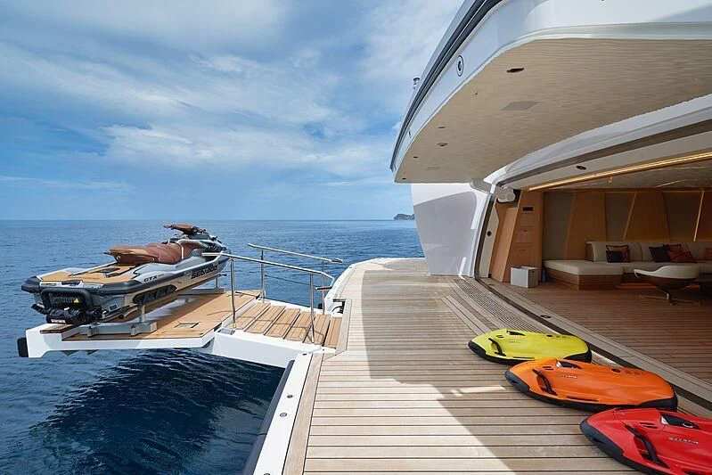 a deck with a boat and a dock with a body of water in the background aboard ARTEFACT Yacht for Sale