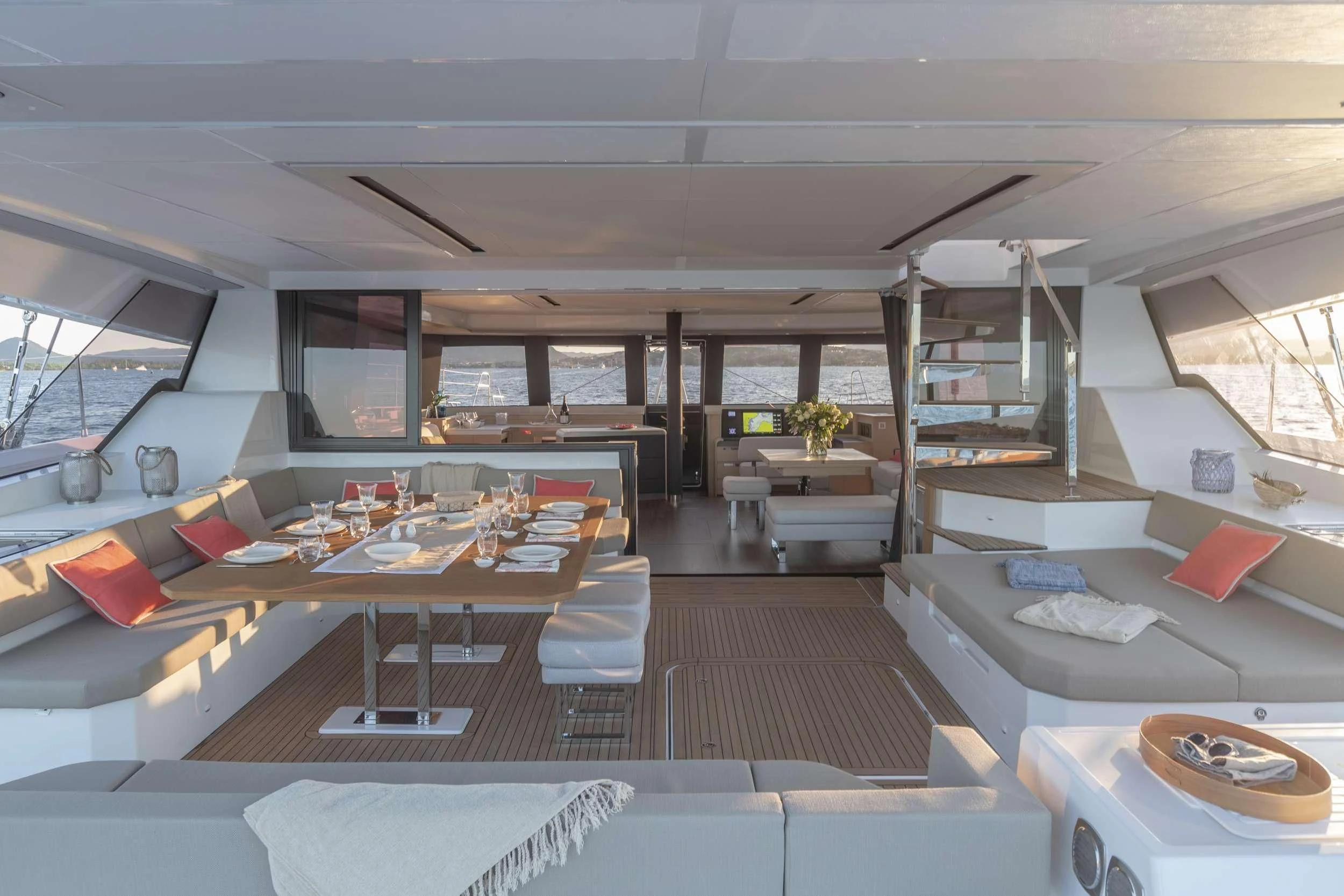 a room with a large window and a table with chairs and a couch aboard KIMATA Yacht for Charter