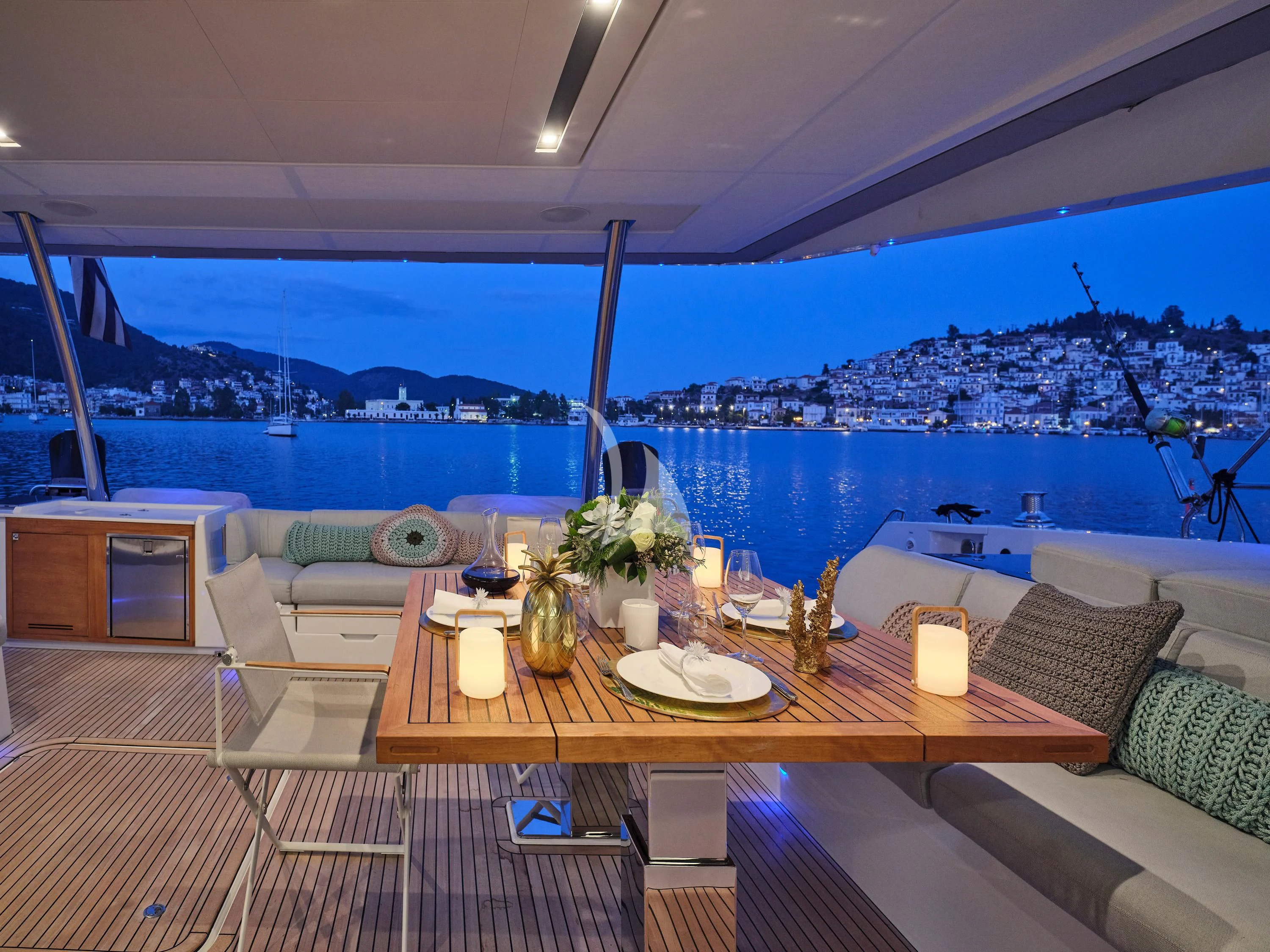 a table with chairs and a view of a city aboard KIMATA Yacht for Charter