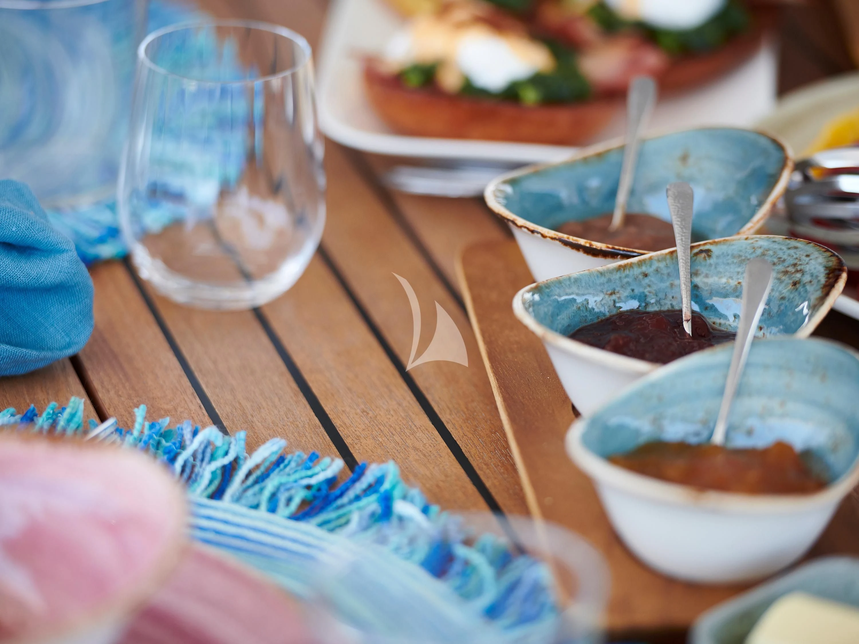 a table with dishes of food and glasses on it aboard KIMATA Yacht for Charter