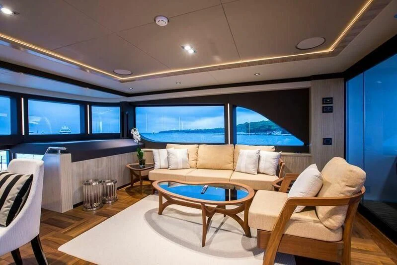 a living room with a large window aboard KRISHH Yacht for Sale