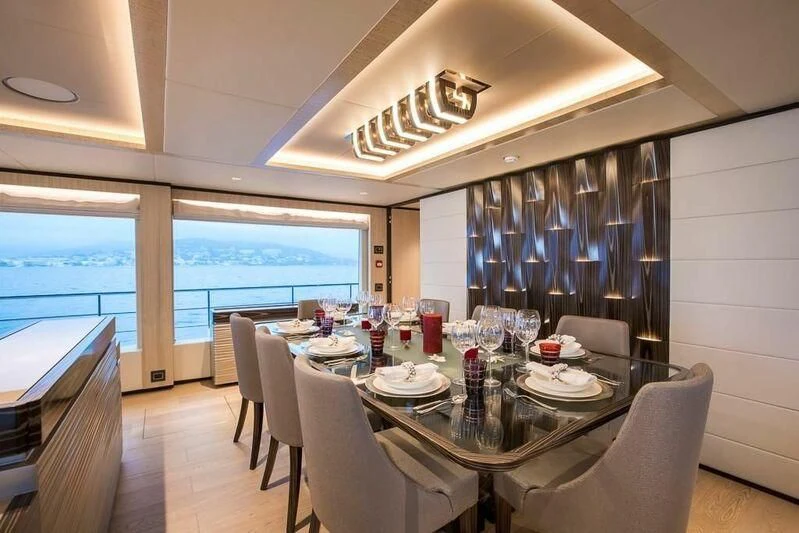 a dining room with a large window aboard KRISHH Yacht for Sale