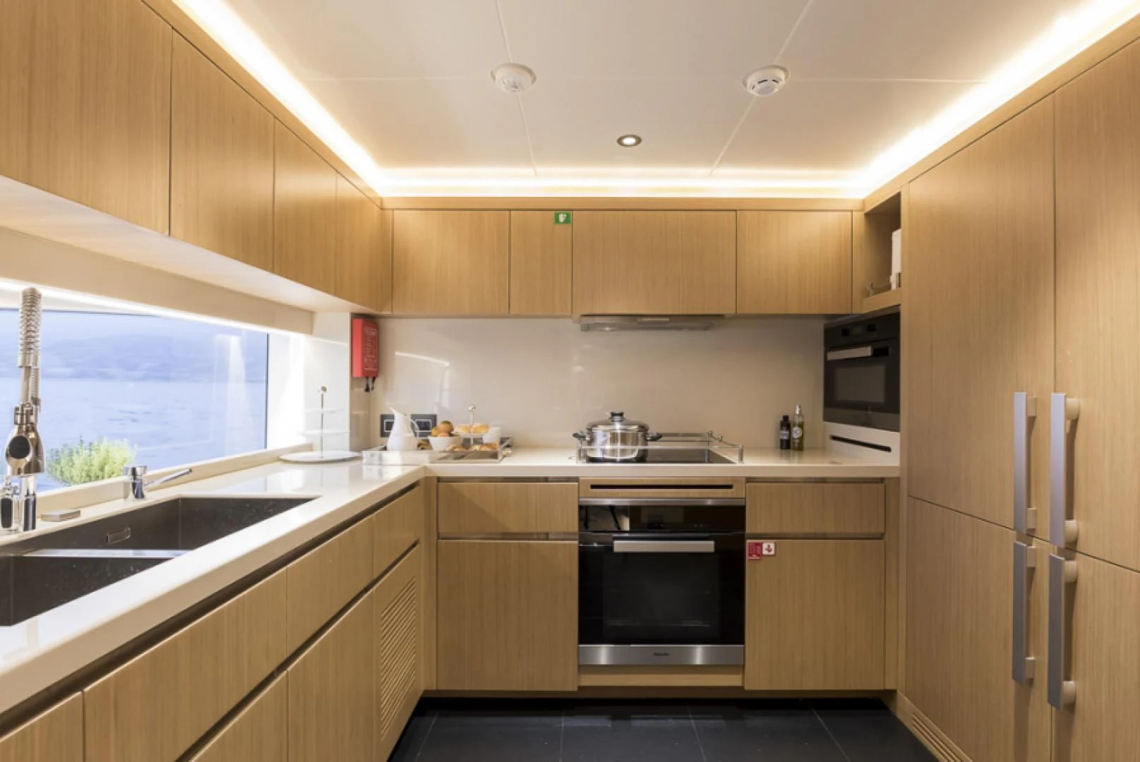 a kitchen with wooden cabinets aboard KRISHH Yacht for Sale