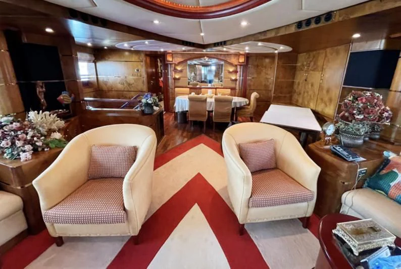 a room with a table chairs and a couch aboard NASAYEM Yacht for Sale