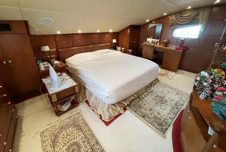 a bedroom with a bed and a table aboard NASAYEM Yacht for Sale