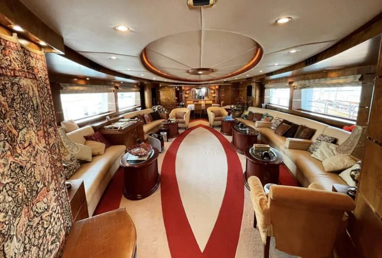 a large room with a red table cloth and chairs aboard NASAYEM Yacht for Sale