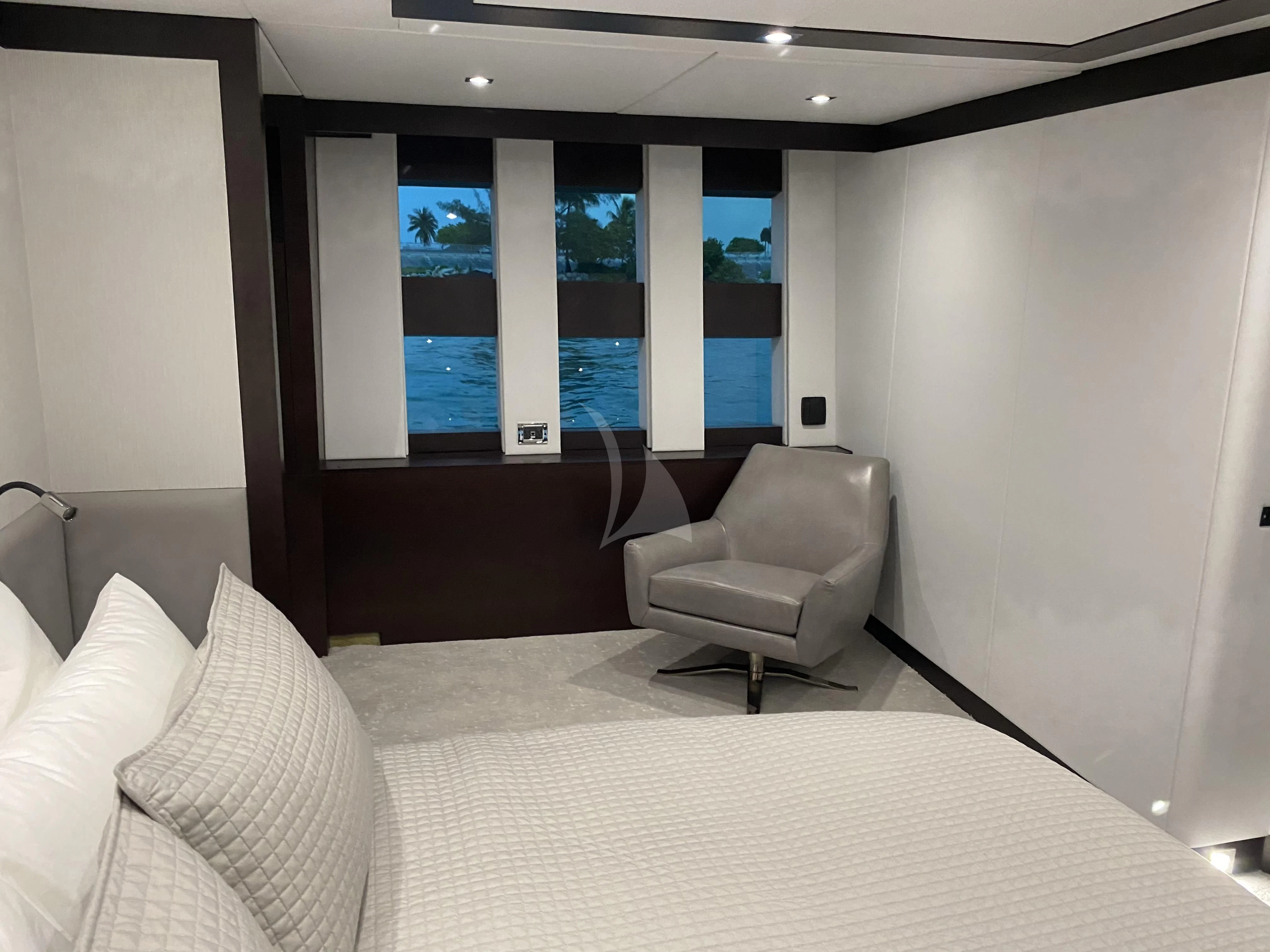 a room with a bed and a chair aboard M Yacht for Charter