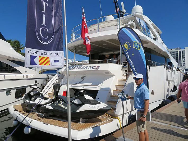 a man standing next to a boat aboard JUST ONE MORE Yacht for Sale