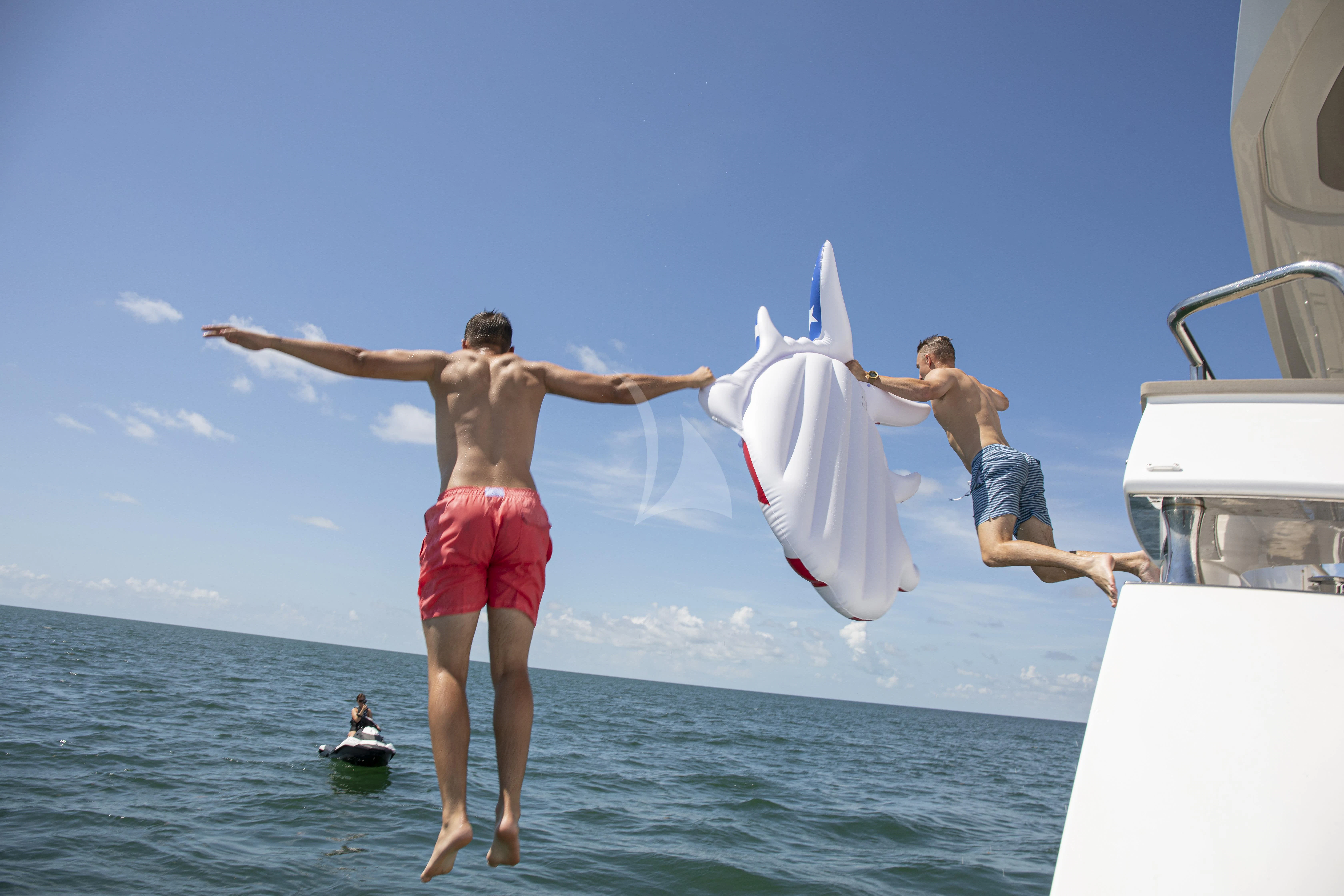 a group of men jumping into the water aboard JUST ONE MORE Yacht for Sale