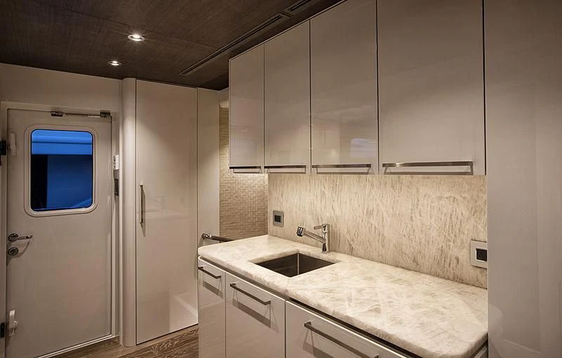 a kitchen with white cabinets aboard SERENITY Yacht for Sale