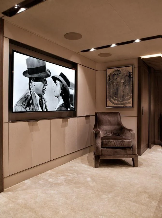 a chair and a couch in a room with paintings on the wall aboard SERENITY Yacht for Sale