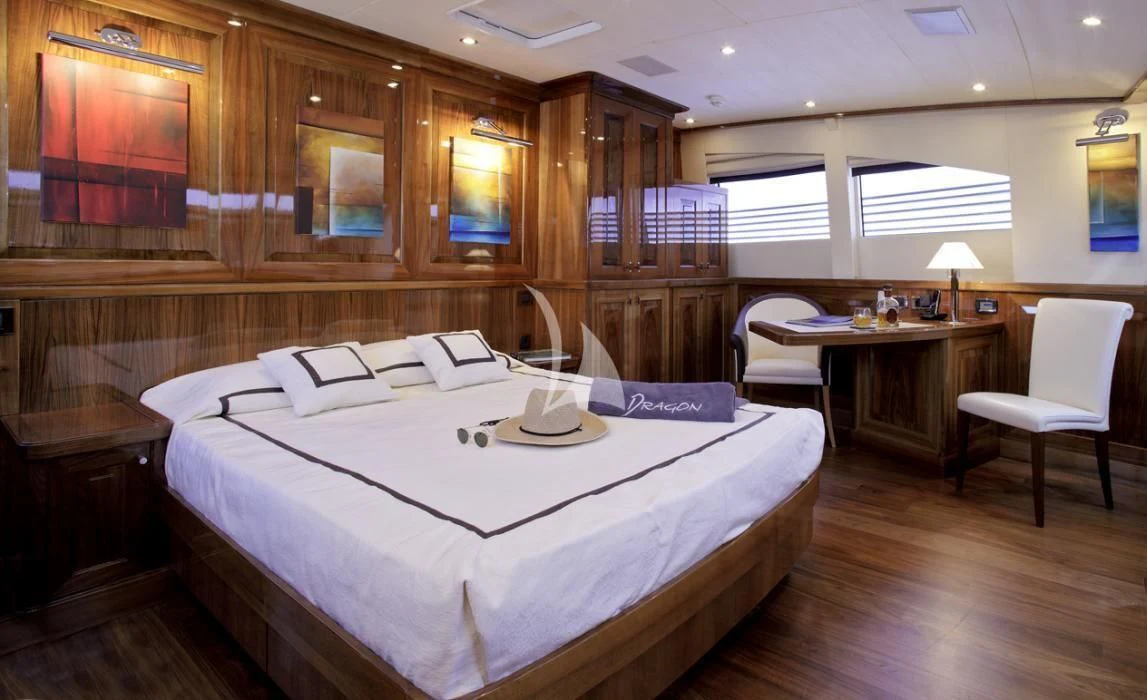 a room with a bed and a table aboard DRAGON Yacht for Sale