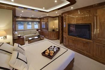 a living room with a tv and a table aboard DRAGON Yacht for Sale