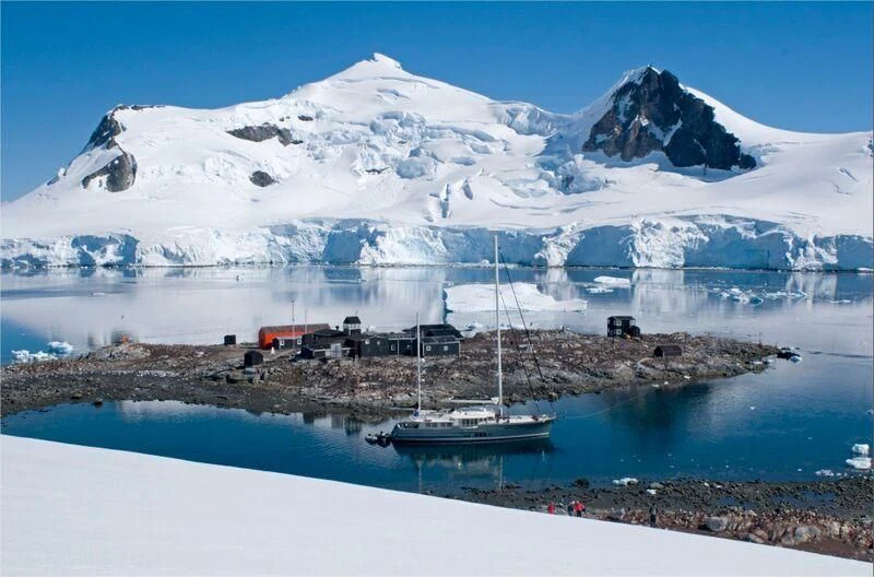a snowy mountain with a boat in the water aboard HORTENSE Yacht for Sale