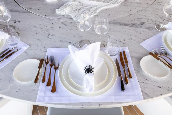 a white napkin on a plate with silverware and silverware aboard VIRTUOSITY Yacht for Sale