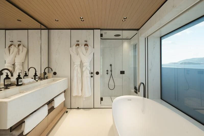 a bathroom with a bathtub sink and a large mirror aboard VIRTUOSITY Yacht for Sale