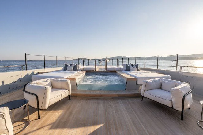 a large pool with a deck overlooking the ocean aboard VIRTUOSITY Yacht for Sale