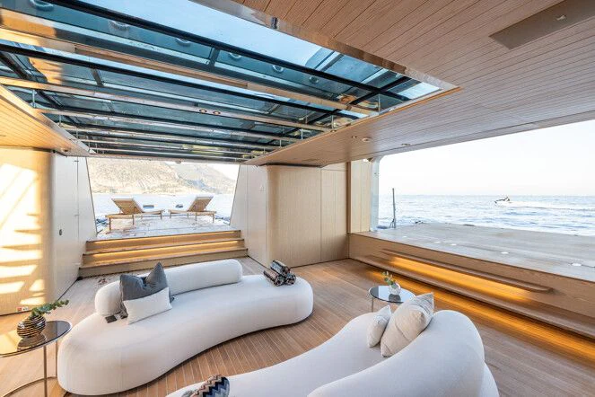 a room with a couch and a large window aboard VIRTUOSITY Yacht for Sale