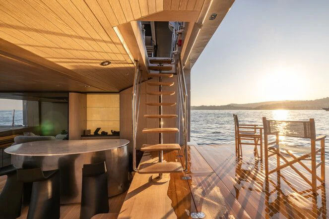 a wooden staircase leading to a balcony aboard VIRTUOSITY Yacht for Sale