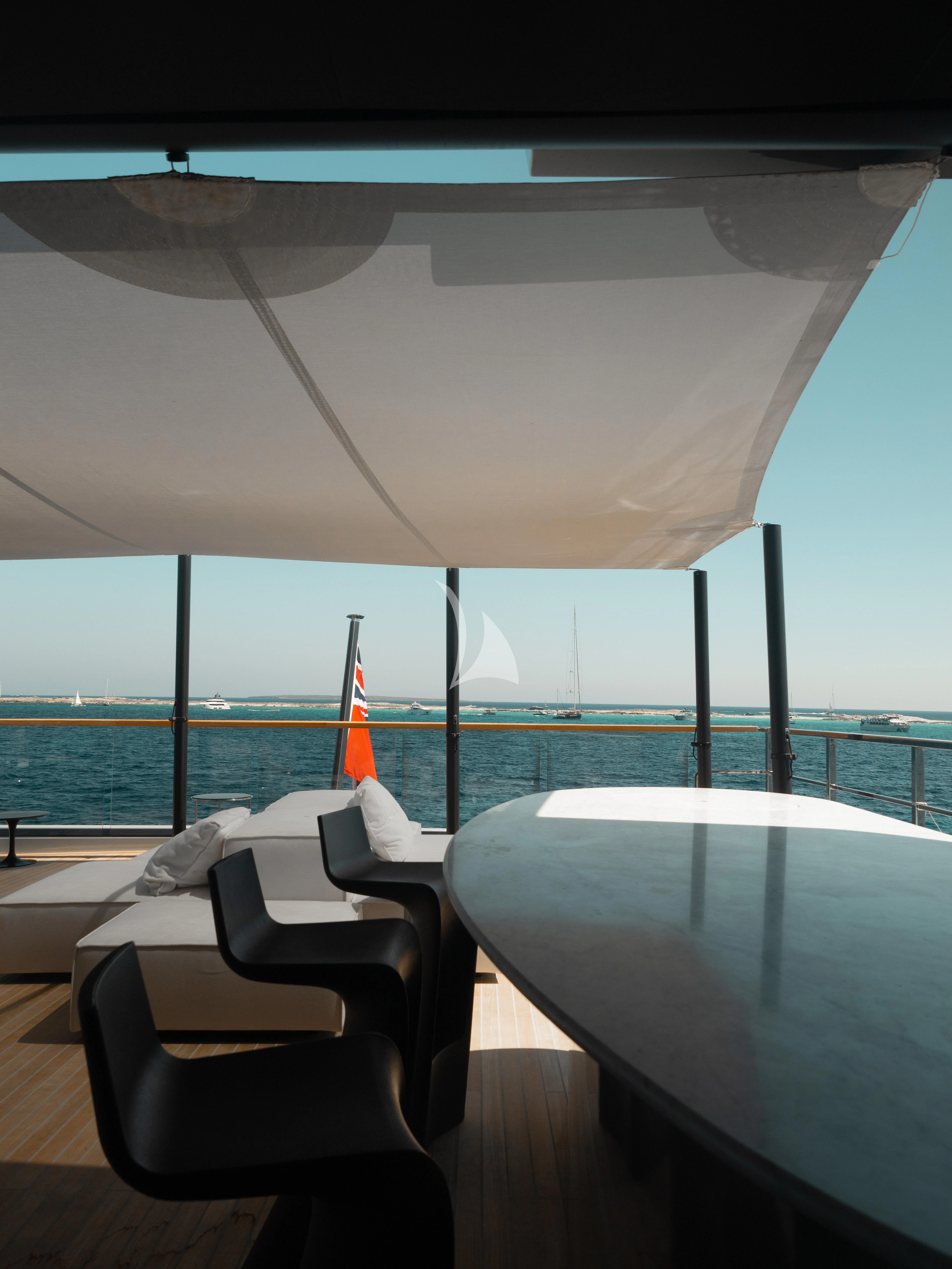 a table and chairs on a balcony aboard VIRTUOSITY Yacht for Sale