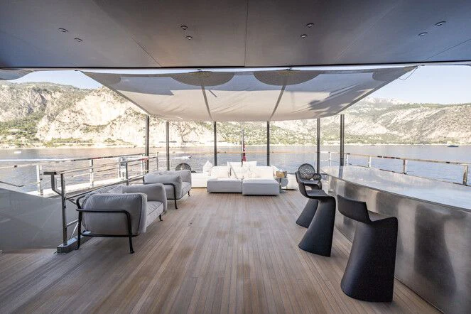 a large room with a table and chairs on a deck aboard VIRTUOSITY Yacht for Sale