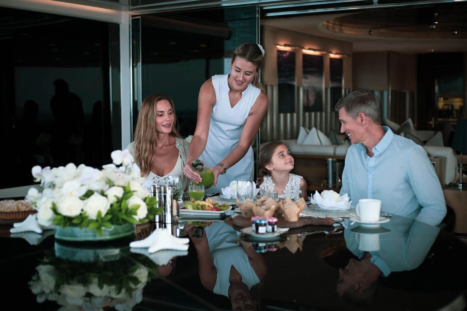 a group of people sitting around a table with food aboard SEALION Yacht for Sale