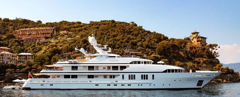 a large white boat in a harbor aboard SEALION Yacht for Sale