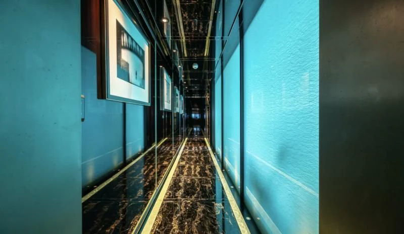 a hallway with a light blue wall aboard SEALION Yacht for Sale