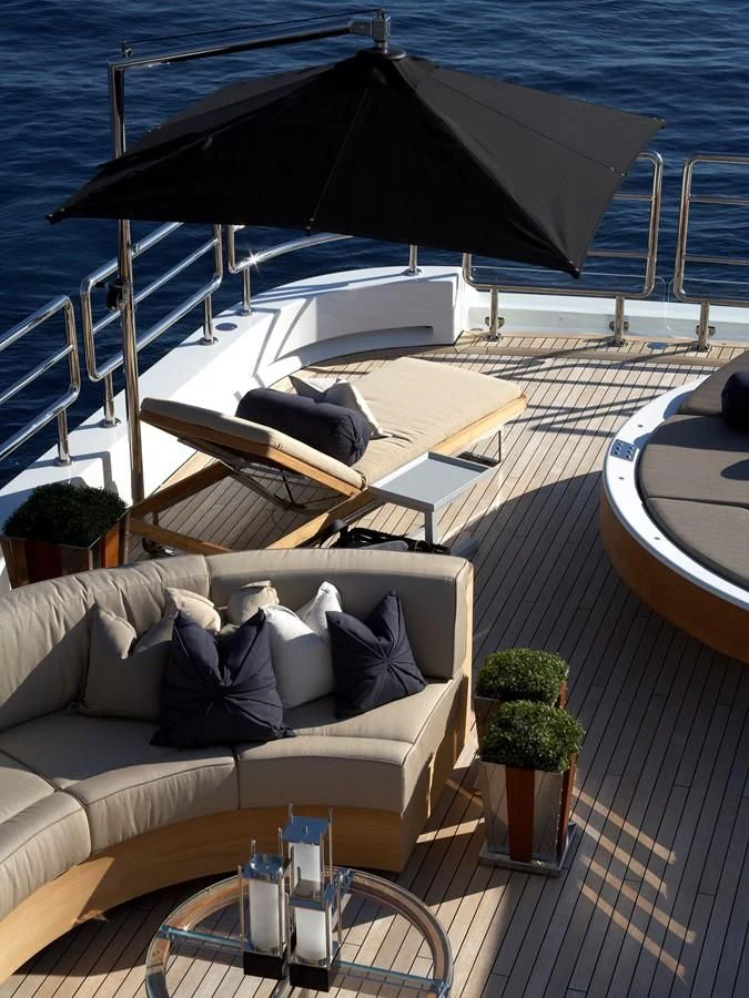 a patio with a couch and a table with a large umbrella aboard SEALION Yacht for Sale