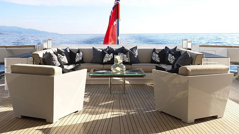 a living room with a large sofa and a red flag aboard SEALION Yacht for Sale