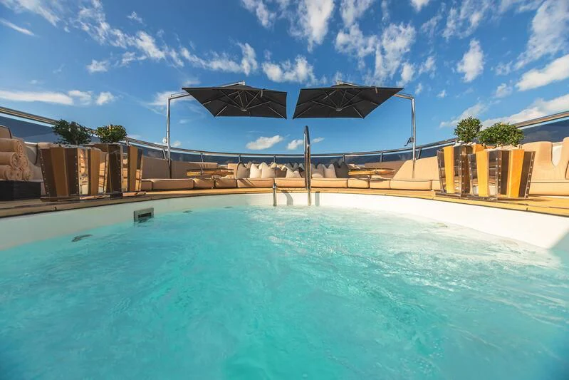 a pool with a building in the background aboard SEALION Yacht for Sale
