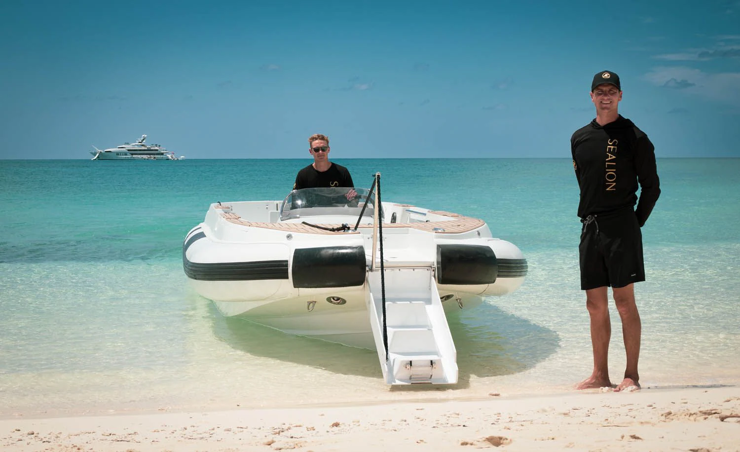 a man and a woman standing next to a boat on a beach aboard SEALION Yacht for Sale