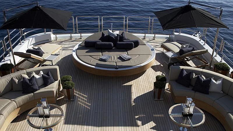 a deck with a boat and umbrellas aboard SEALION Yacht for Sale