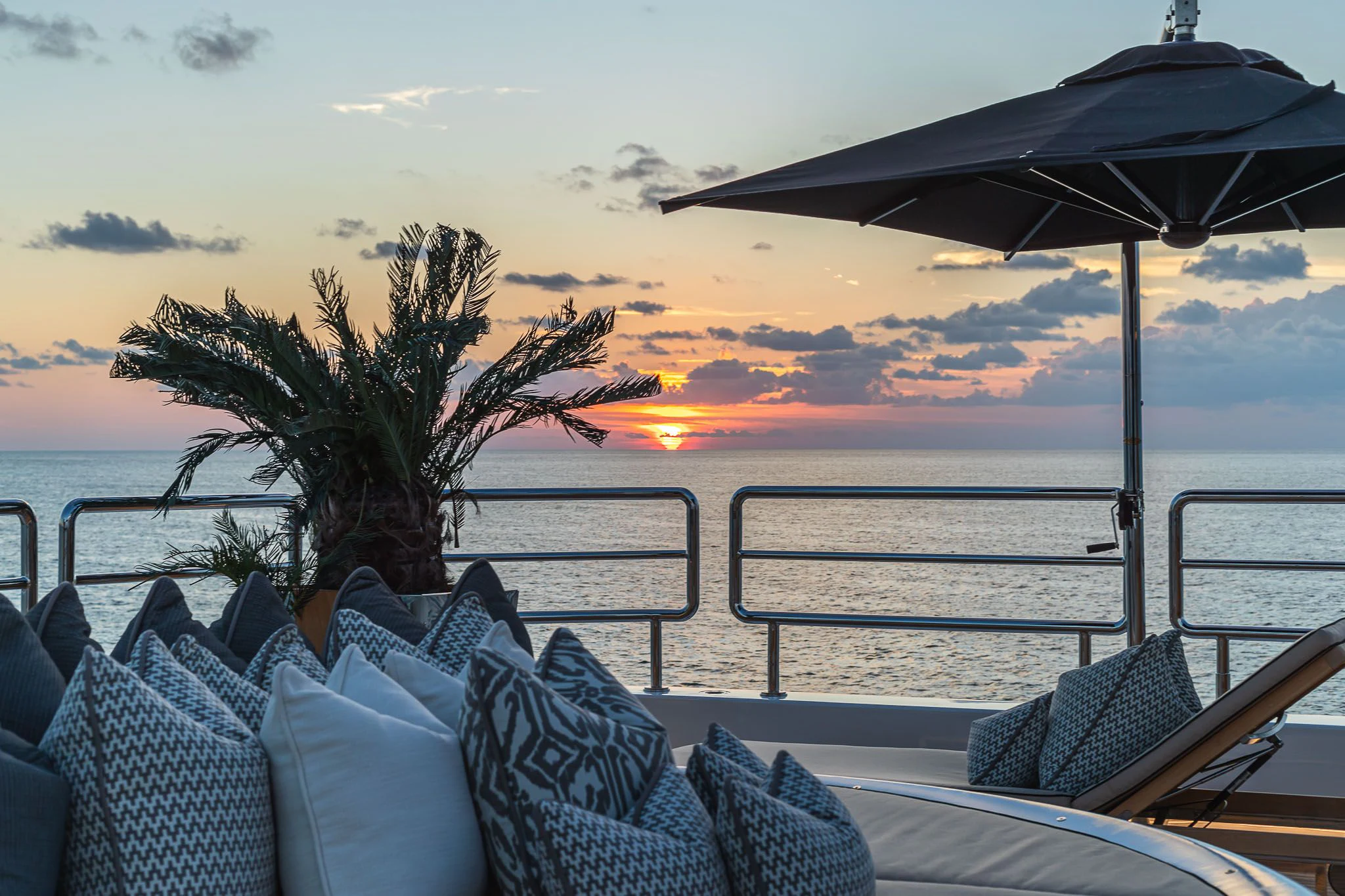 a deck with a tree and a body of water in the background aboard SEALION Yacht for Sale