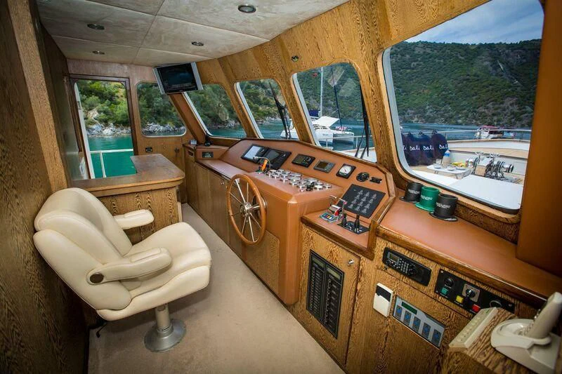 a room with a wood bench and a window aboard DALI Yacht for Sale