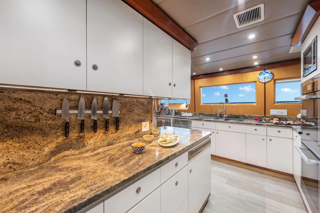 a kitchen with white cabinets aboard SURINA Yacht for Sale