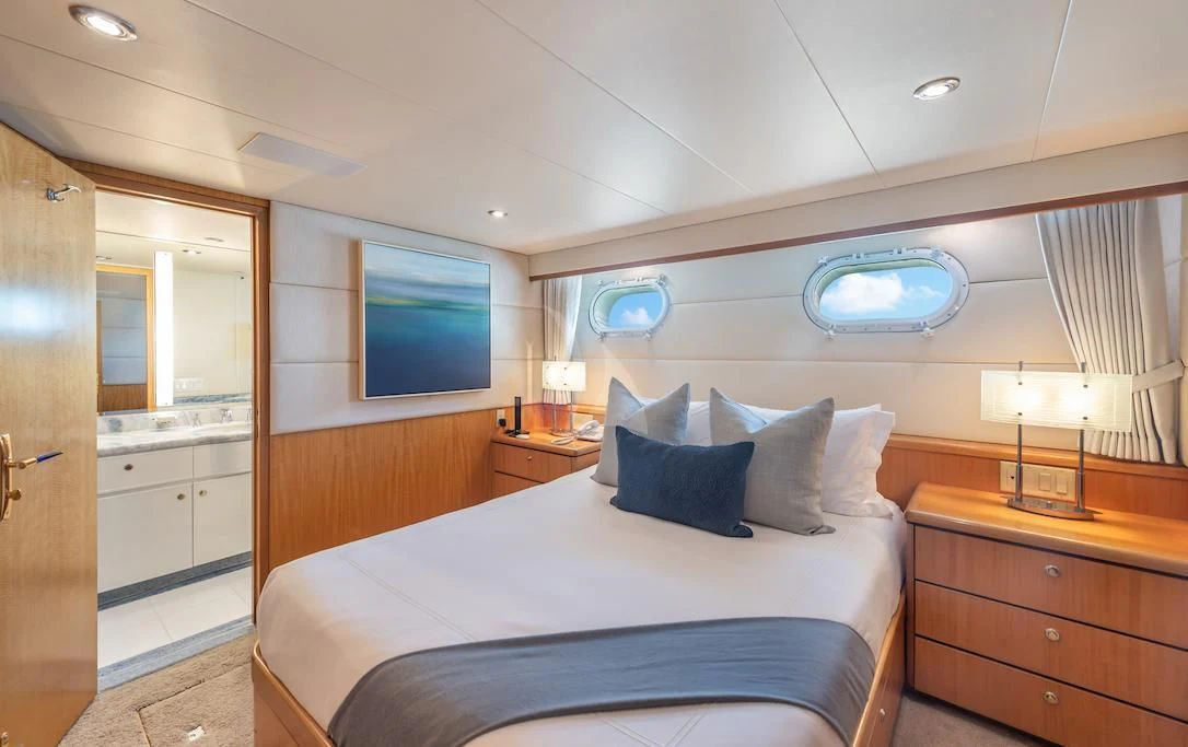 a bedroom with a bed and a tv on the wall aboard SURINA Yacht for Sale