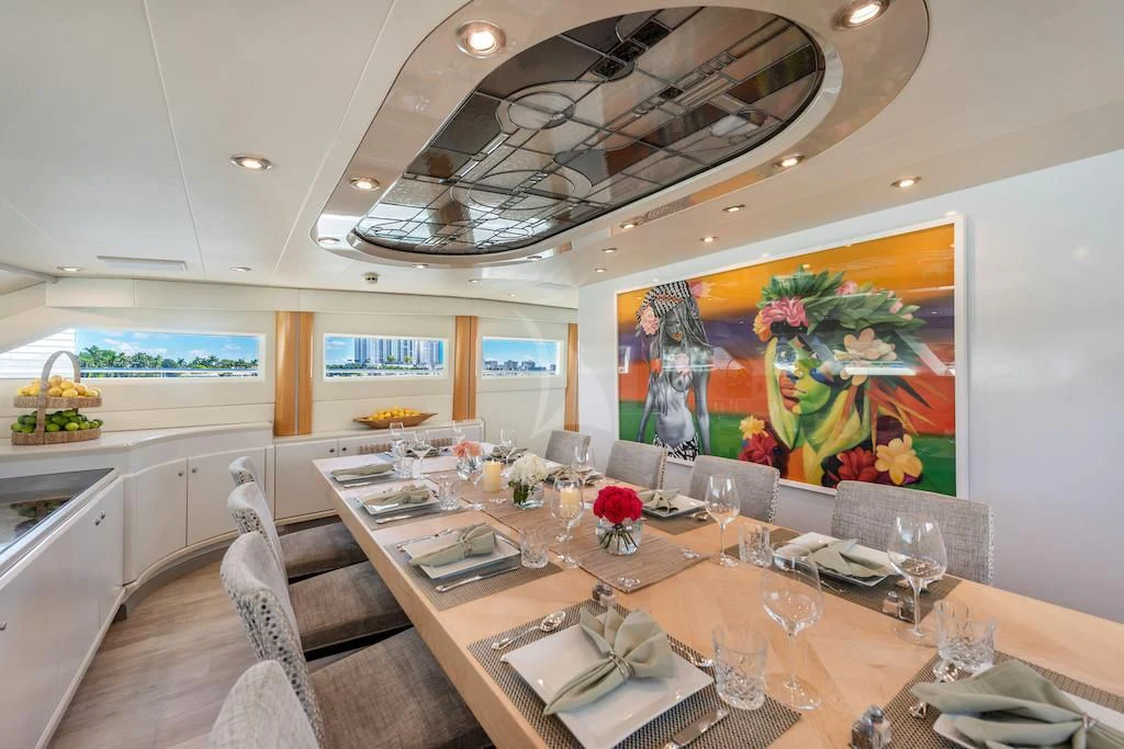 a large dining table with a large painting above it aboard SURINA Yacht for Sale
