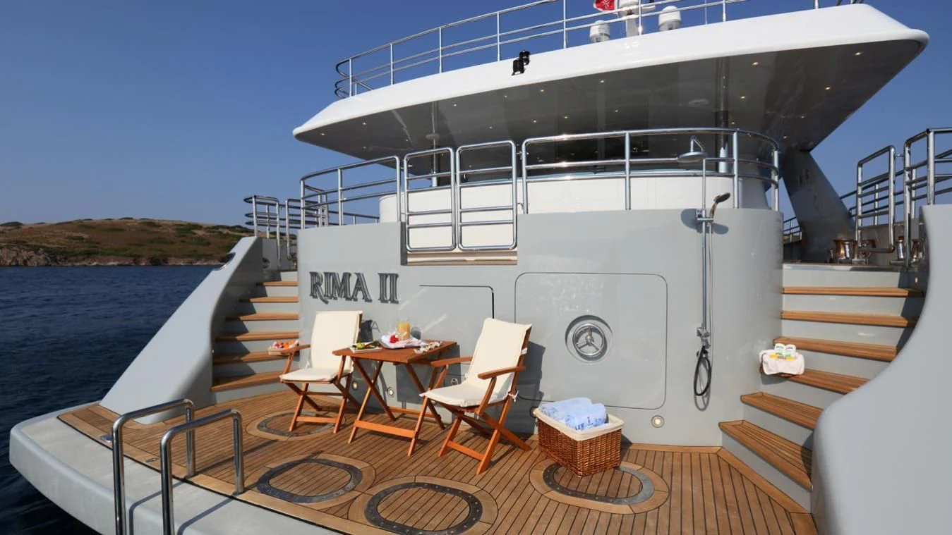 a deck with a table and chairs on it aboard EGO Yacht for Sale
