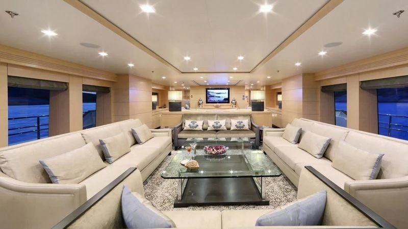 a living room with a table and couches aboard EGO Yacht for Sale