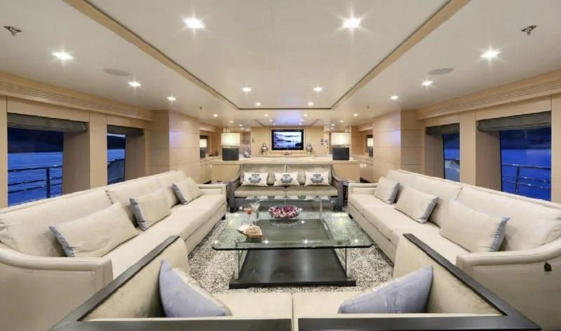 a living room with a table and couches aboard EGO Yacht for Sale