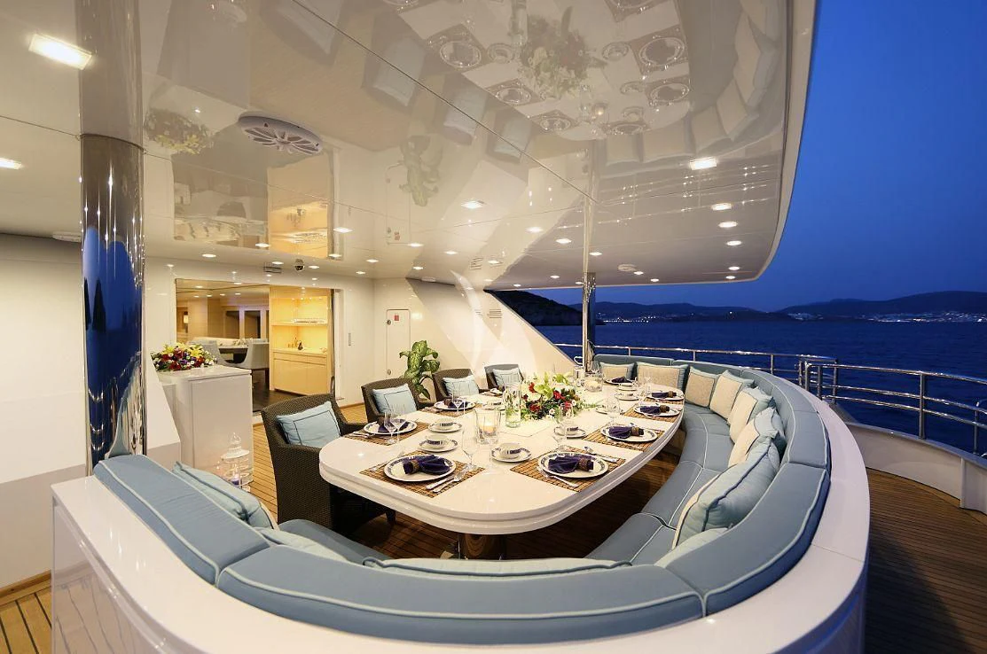 a large white room with a large table and chairs aboard EGO Yacht for Sale