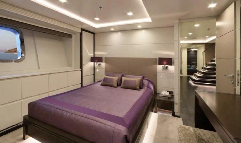 a bedroom with a purple bed aboard EGO Yacht for Sale