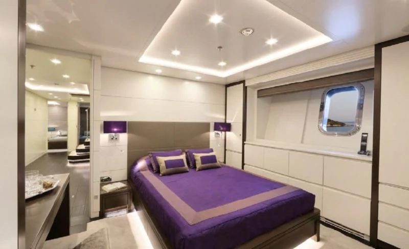 a bedroom with a purple bed aboard EGO Yacht for Sale