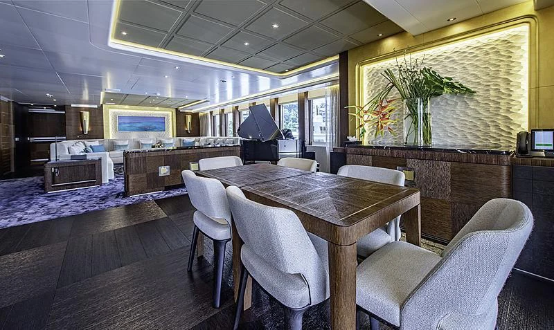 a large room with a table and chairs aboard WHITE RABBIT Yacht for Sale